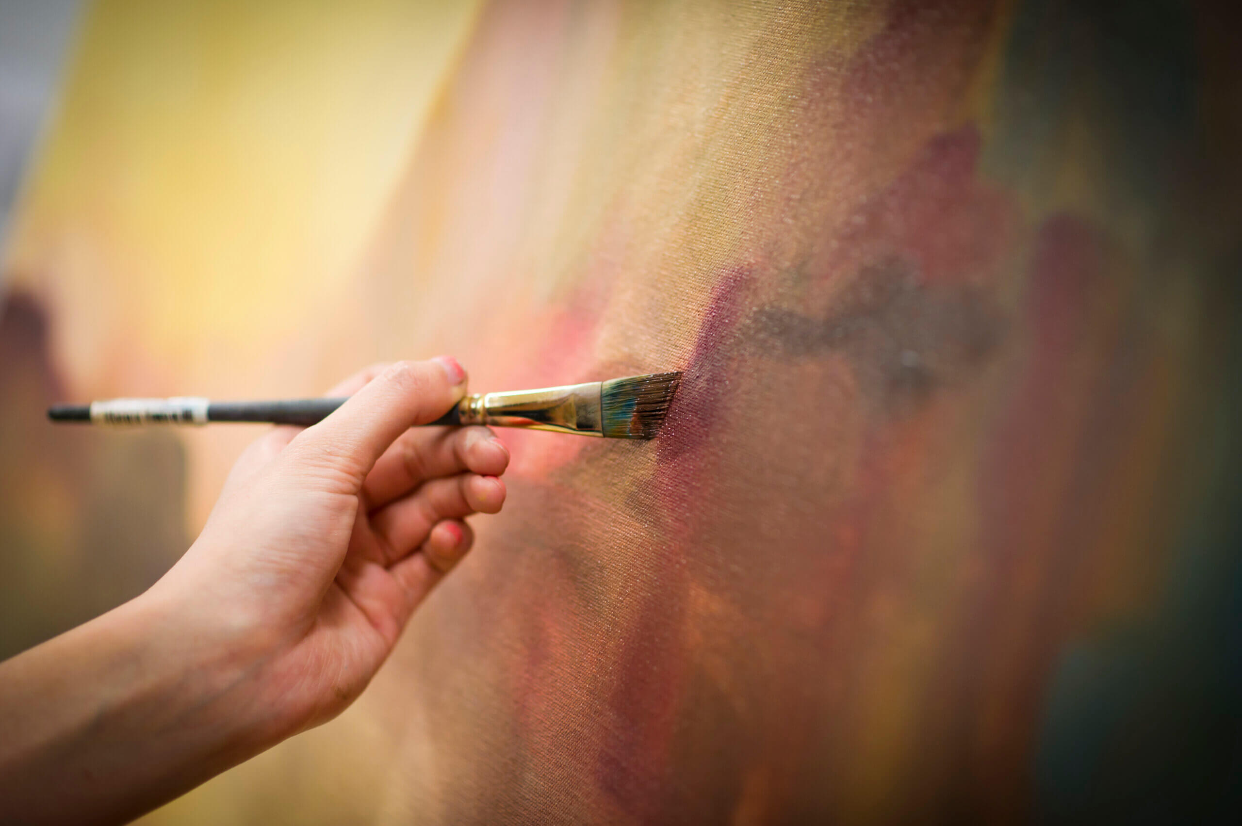 Rutgers University - Mason Gross School of the Arts Hand holding paintbrush on canvas