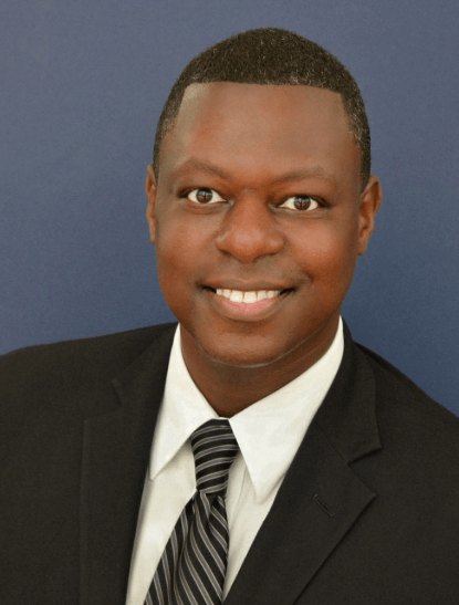 Man in suit and tie smiling at the camera.