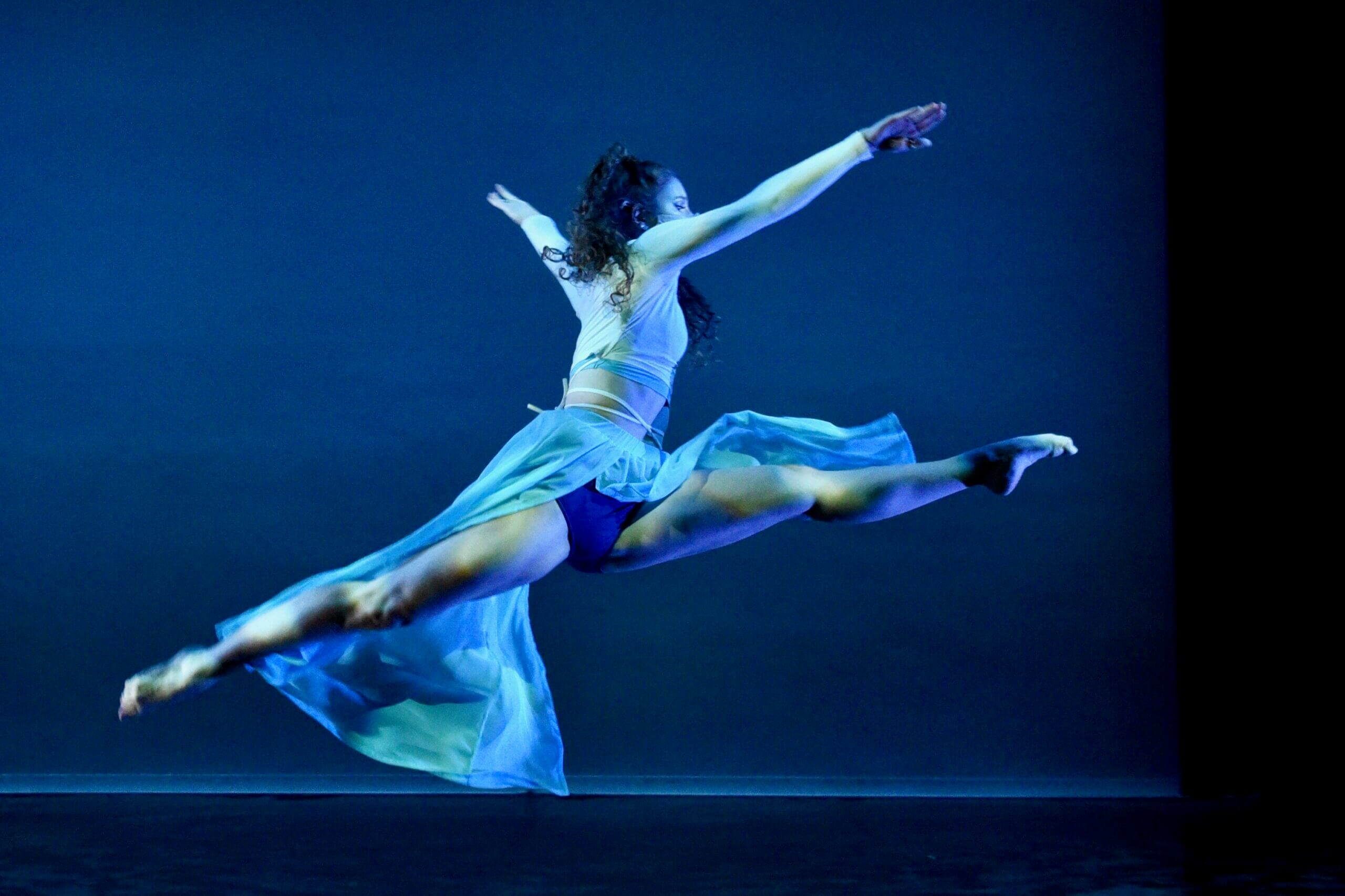 A dancer leaping on stage. 