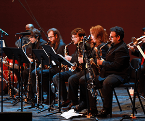 Group of seated musicians performing with various instruments