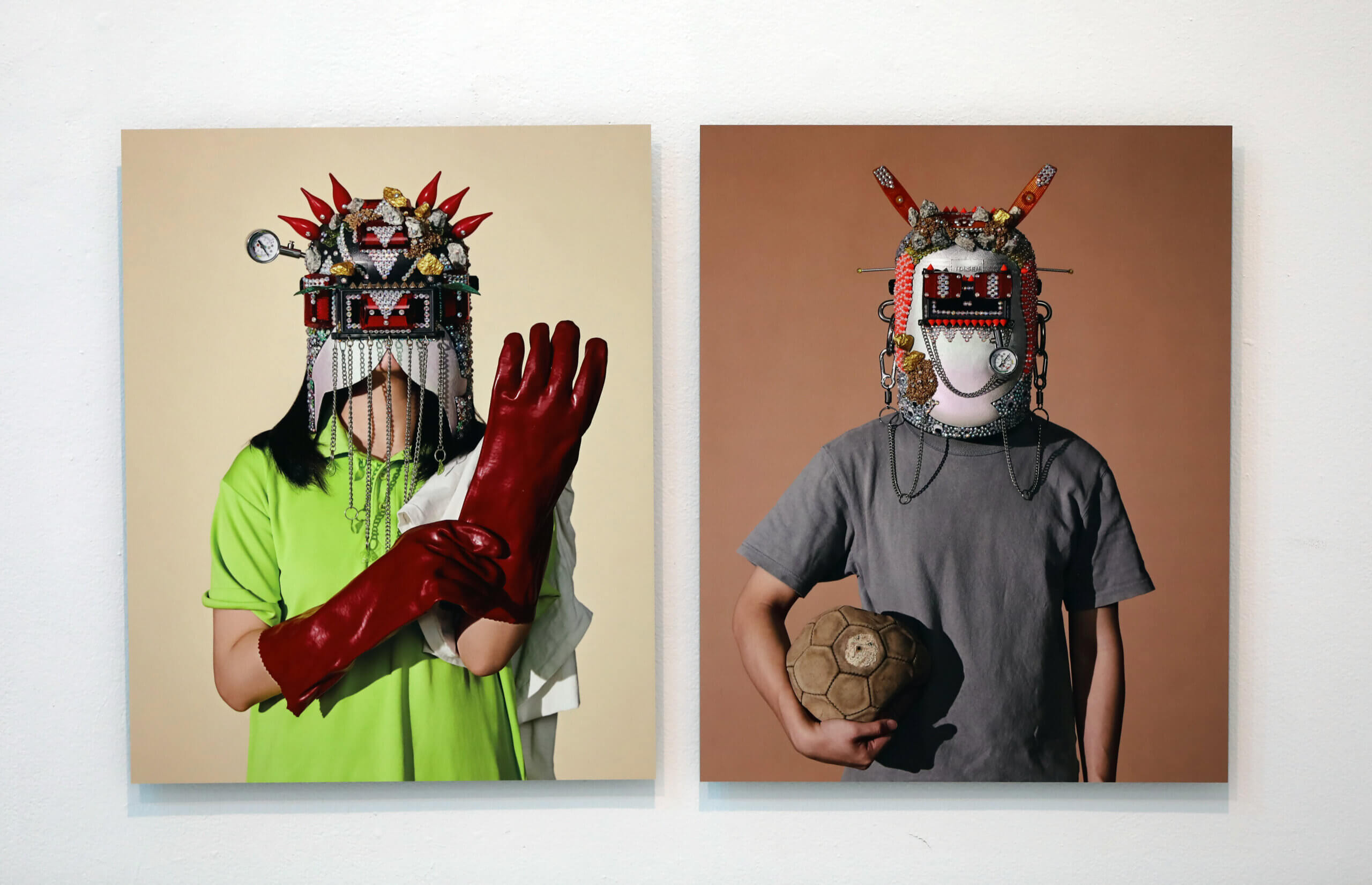Two portraits on the wall each of a person wearing a decorated helmet.