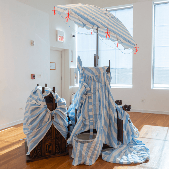 Artwork of an umbrella and fabric in a room with windows and sunlight shining through.