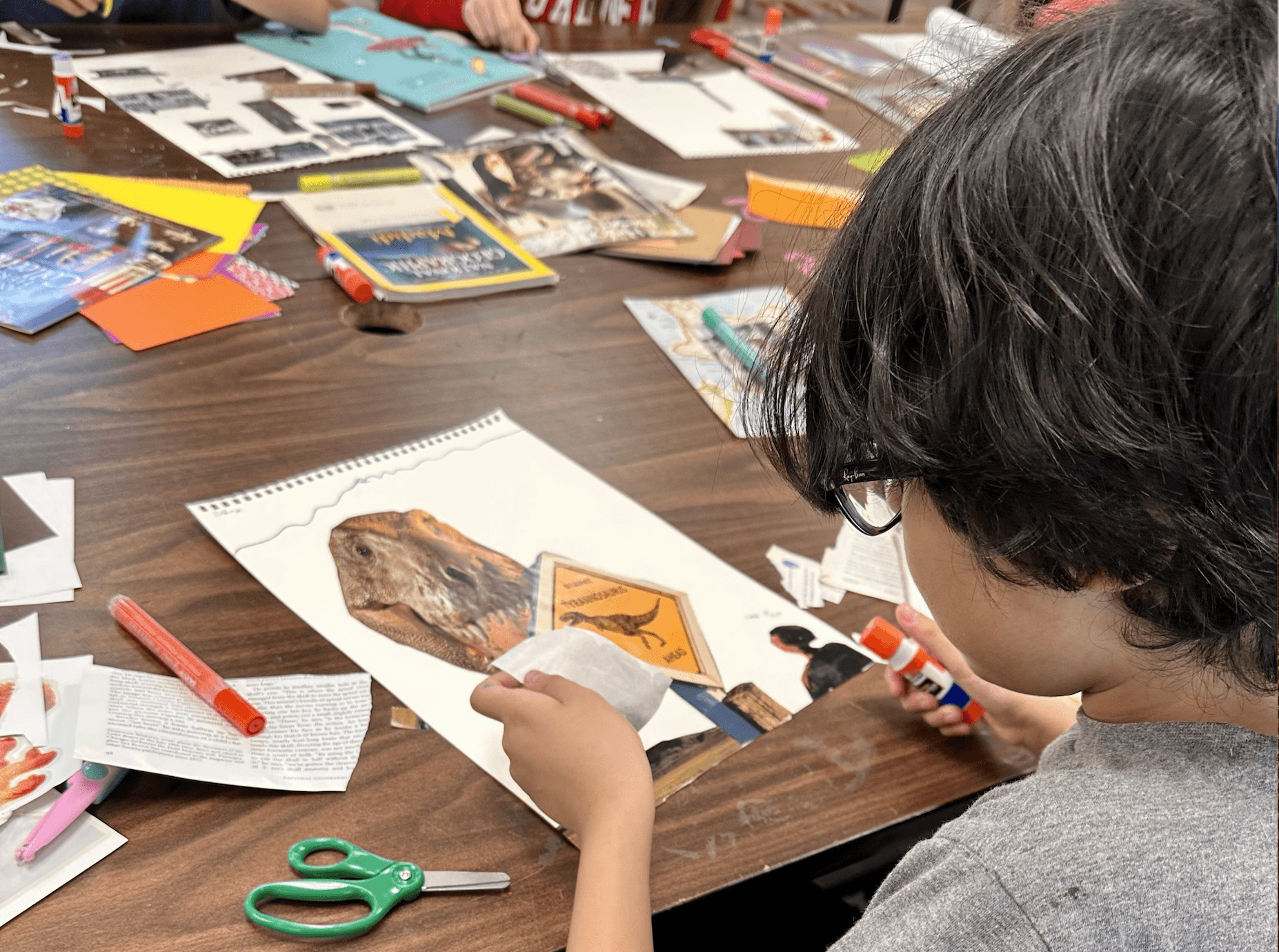 Child sitting at a table doing crafts.